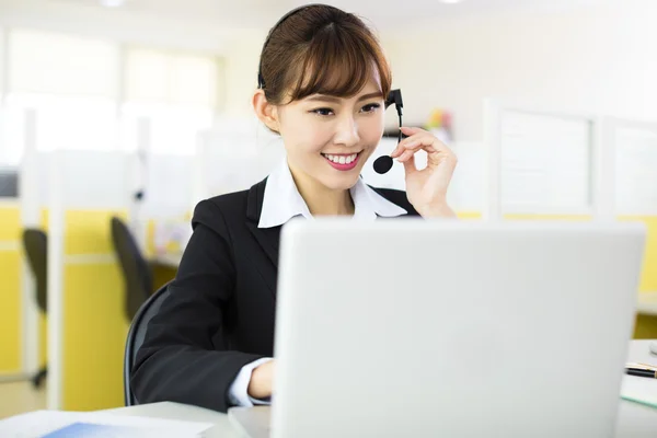 Joven hermosa mujer de negocios con auriculares en la oficina —  Fotos de Stock