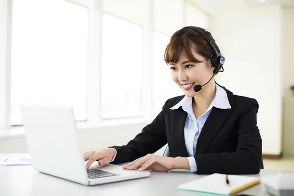 Young beautiful  businesswoman with headset in office — Stock Photo, Image