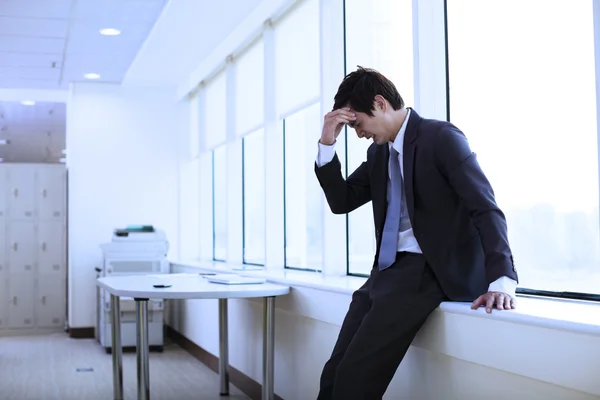 Depressed young businessman in office Royalty Free Stock Images
