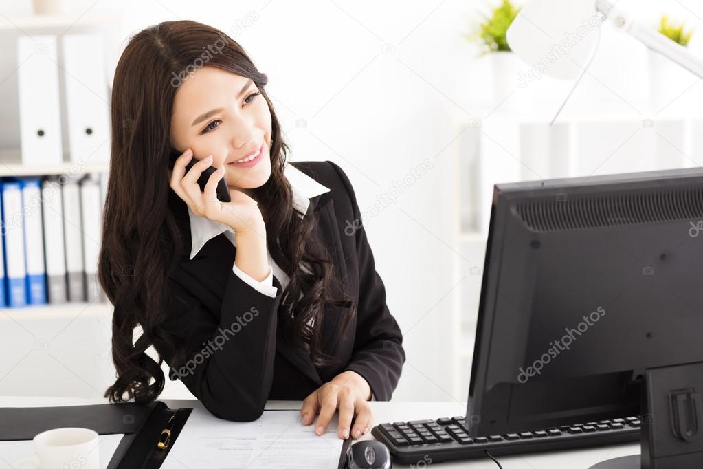 Young business woman talking on the phone in the office