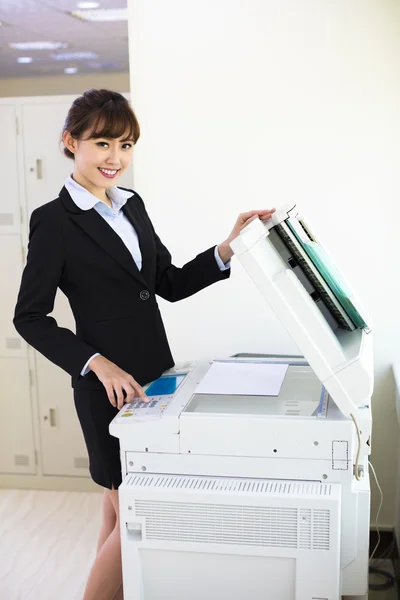 Mladá podnikatelka pomocí kopírovacího stroje v kanceláři — Stock fotografie