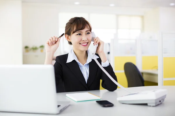 O femeie de afaceri vorbind la telefon la birou — Fotografie, imagine de stoc