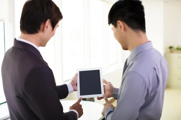 Socios de negocios mirando tableta y discutir — Foto de Stock