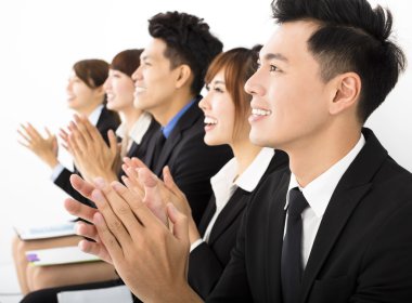 Business people sitting in a row and applauding clipart