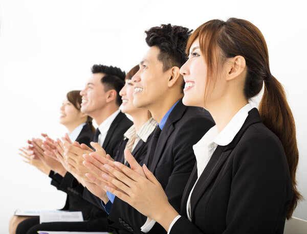 Деловые люди сидят в ряд и аплодируют
