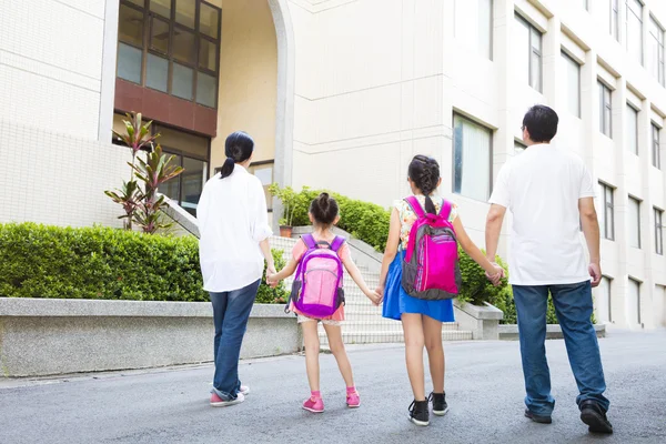 Padre e madre a piedi a scuola con i bambini — Foto Stock