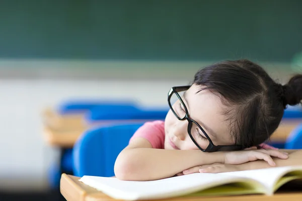 Маленькая девочка спит в очках в классе — стоковое фото