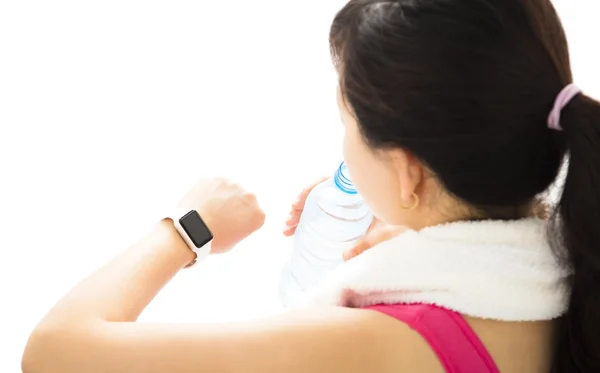 Mujer joven mirando deportes reloj inteligente —  Fotos de Stock