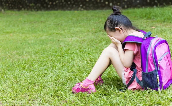 Stressmädchen sitzen und denken im Gras — Stockfoto