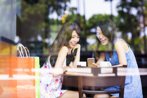 Glad ung kvinna tittar på telefonen i kafé — Stockfoto
