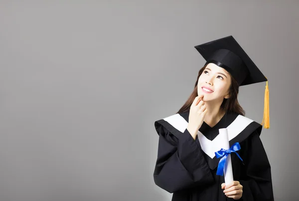 Bela jovem graduado segurando diploma e pensamento — Fotografia de Stock