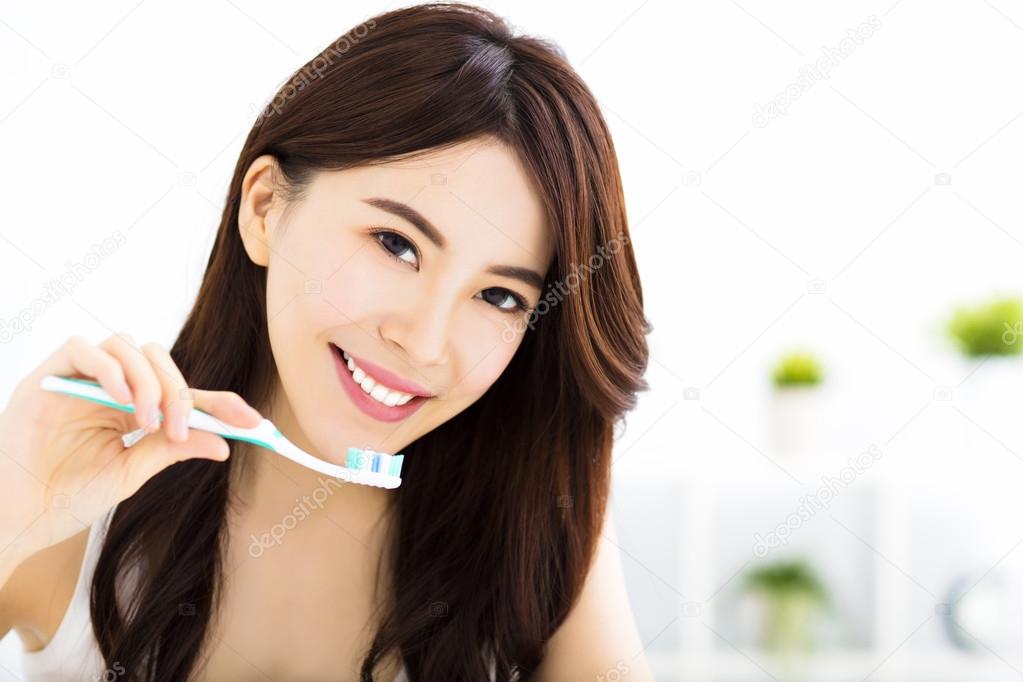 Young woman  brushing teeth in the morning