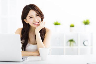 Dizüstü bilgisayar ile genç gülümseyen Asyalı kadın