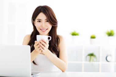 Genç gülümseyen Asyalı kadın kahve içme