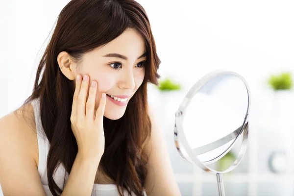 Happy young woman  looking on mirror — Stock Photo, Image
