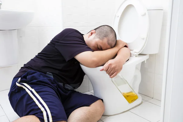 Opilý tlustý muž s láhví vína v záchodě — Stock fotografie