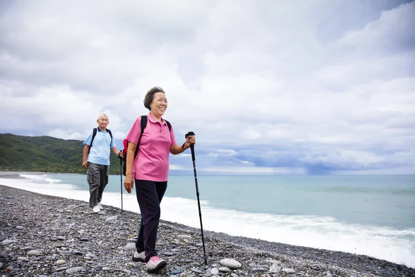 Щаслива старша пара пішохідна на узбережжі пляжу — стокове фото
