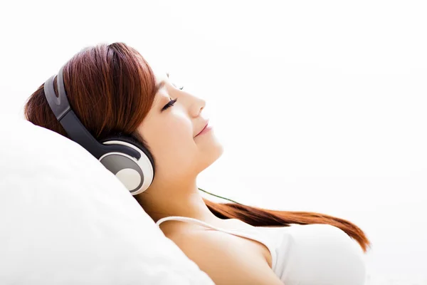 Avslappnad ung kvinna med hörlurar lyssna musik — Stockfoto