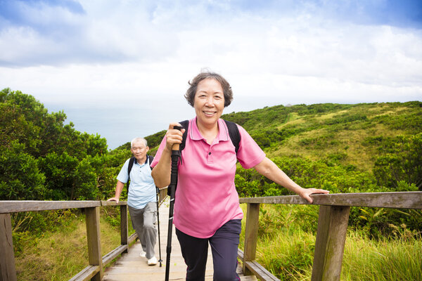 happy senior couple hiking on the mountain