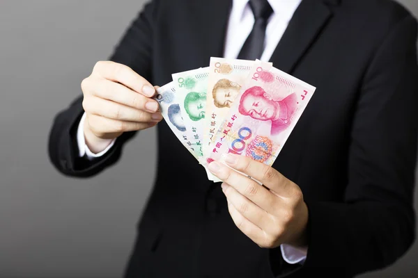 Uomo d'affari in possesso di yuan RMB nelle sue mani — Foto Stock