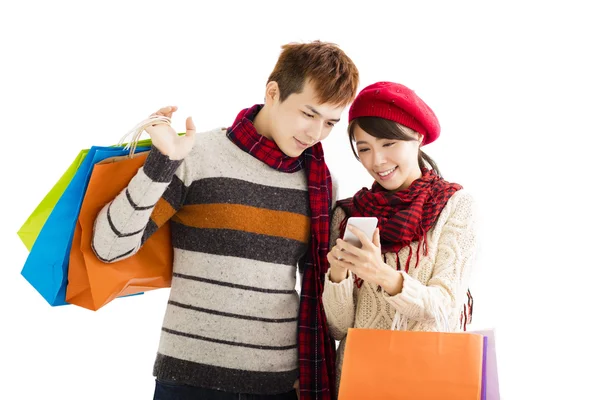 Happy couple shopping together and looking smart phone — Stock Photo, Image