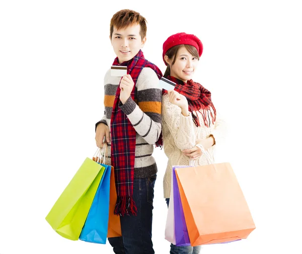 Jovem casal com sacos de compras e cartão de crédito — Fotografia de Stock