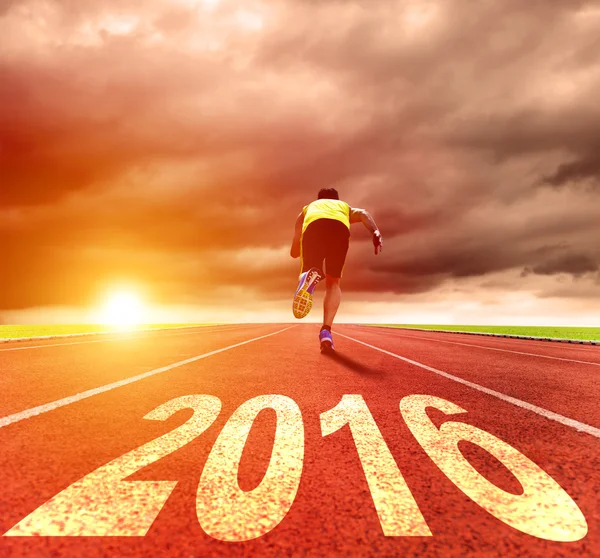 С Новым годом 2016. Молодой человек бежит с восходом солнца — стоковое фото