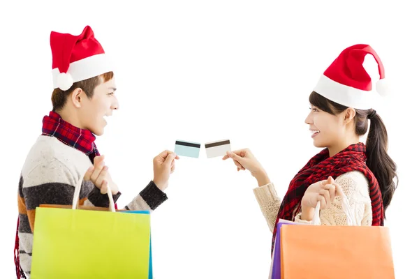 Pareja joven con bolsas de compras y tarjeta de crédito para Navidad —  Fotos de Stock