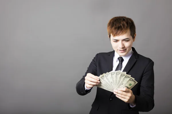 Happy young businessman counts dollar  money in hands — Stock Photo, Image