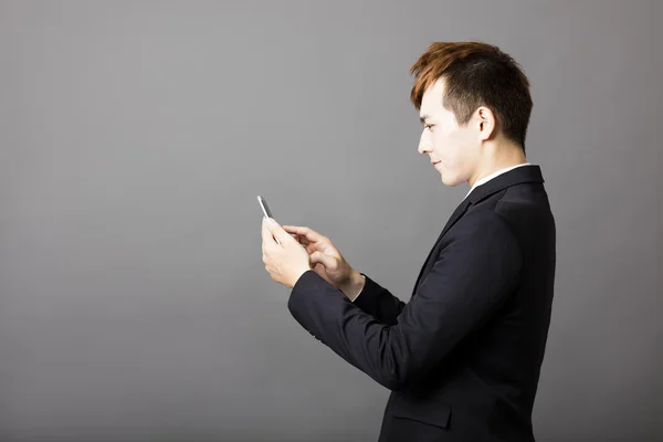 Молодой бизнесмен проверяет сообщения по телефону — стоковое фото