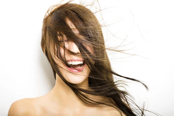 Ung kvinna med hår rörelse på vit bakgrund — Stockfoto