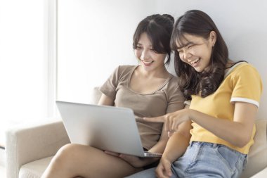 Evdeki kanepede dizüstü bilgisayarlı mutlu öğrenci kızlar.