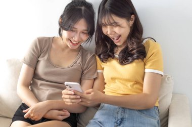 Akıllı telefonu izleyen mutlu öğrenci kızlar. 