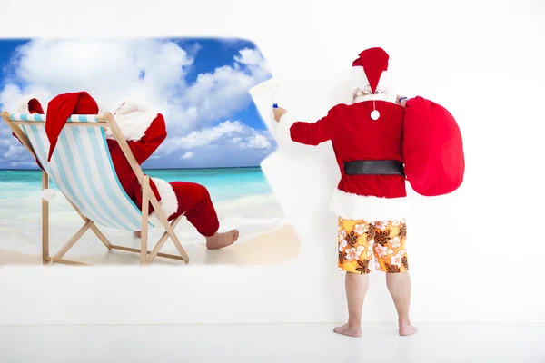 Weihnachtsmann mit Bademode und gemaltem Urlaubskonzept an Wand — Stockfoto