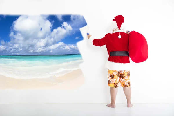 Weihnachtsmann mit Bademode und gemaltem Urlaubskonzept an Wand — Stockfoto