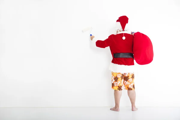 Weihnachtsmann mit Bademode und Malerei an der weißen Wand — Stockfoto