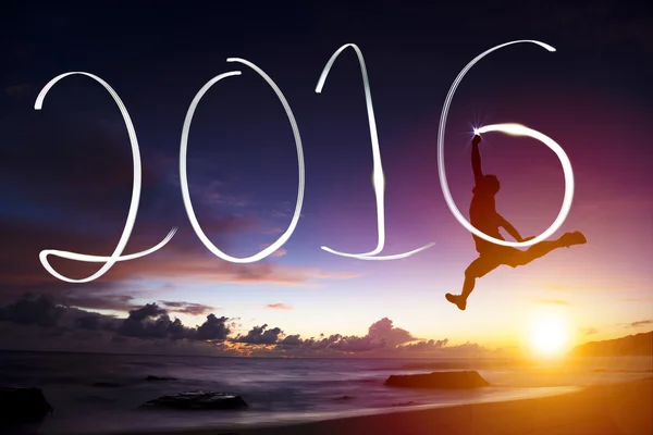 Gelukkig Nieuwjaar 2016.young man springen en 2016 puttend uit strand — Stockfoto