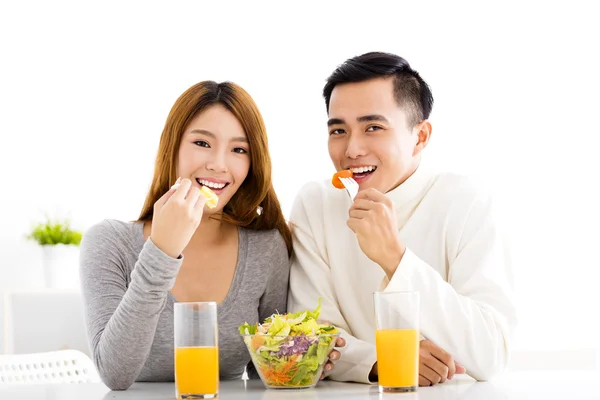 Jovem casal sorrindo comer alimentos saudáveis — Fotografia de Stock