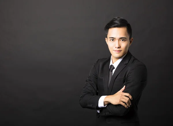 Young asian businessman on black background — Stock Photo, Image