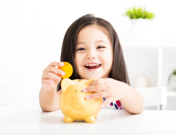 Happy little girl with a piggy bank — Stock Photo, Image