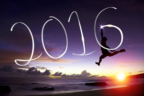 Glad ung man hoppa och dra 2016 i luften — Stockfoto