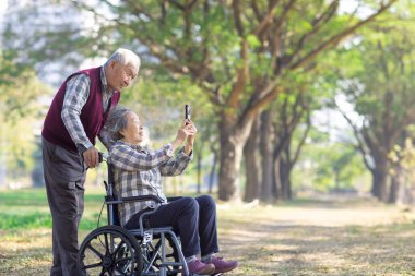 Cep telefonuyla Dijital Belleği Paylaşan Asyalı Yaşlı Çift