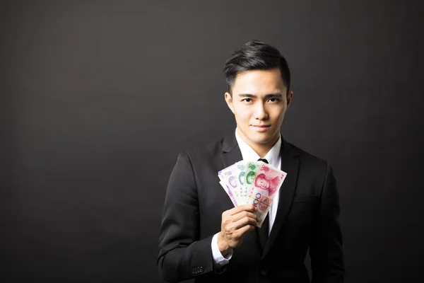 Affärsman håller yuan pengar i hans händer — Stockfoto