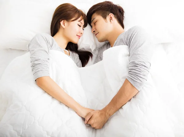 Mutlu genç güzel çift bir yatakta yatarken — Stok fotoğraf