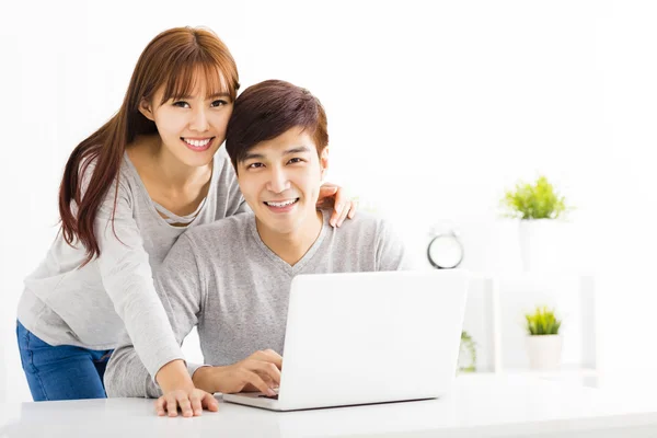 Gelukkige jonge paar met Laptop In de woonkamer — Stockfoto