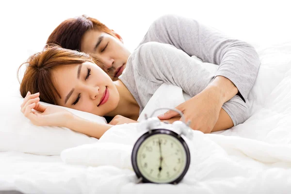 Cuplu tânăr dormind în pat lângă un ceas deşteptător — Fotografie, imagine de stoc