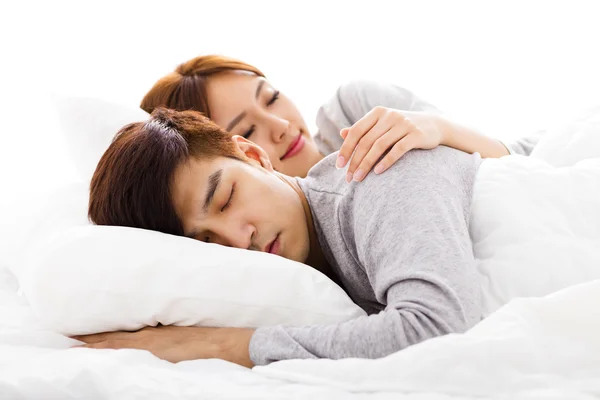 Jovem feliz lindo casal deitado em uma cama — Fotografia de Stock