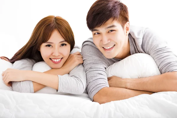 Šťastný mladý pár leží v posteli — Stock fotografie