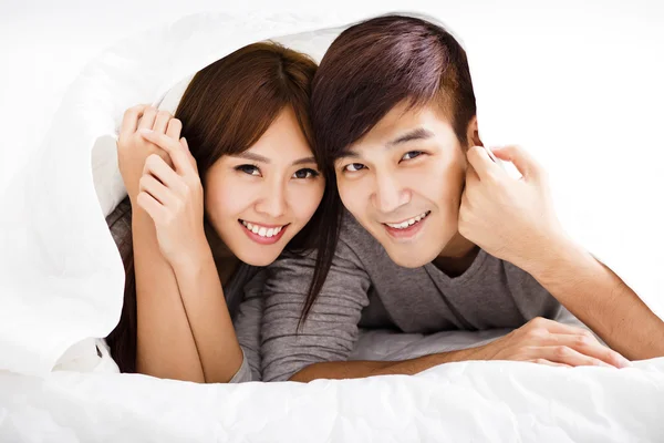 Happy young couple lying in a bed — Stock Photo, Image