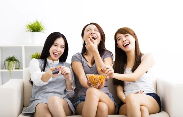 Felice giovane donna di gruppo mangiare spuntini e guardare la tv — Foto Stock